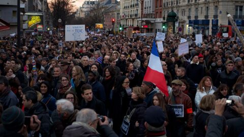 A large crowd marching in a street protest