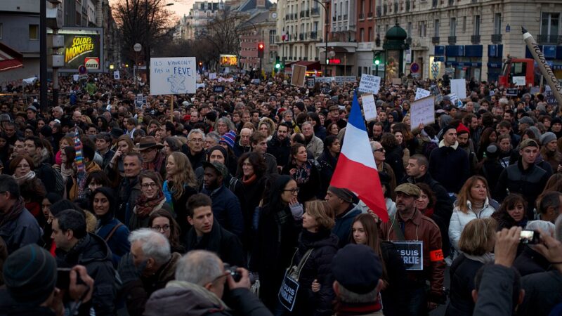 A large crowd marching in a street protest
