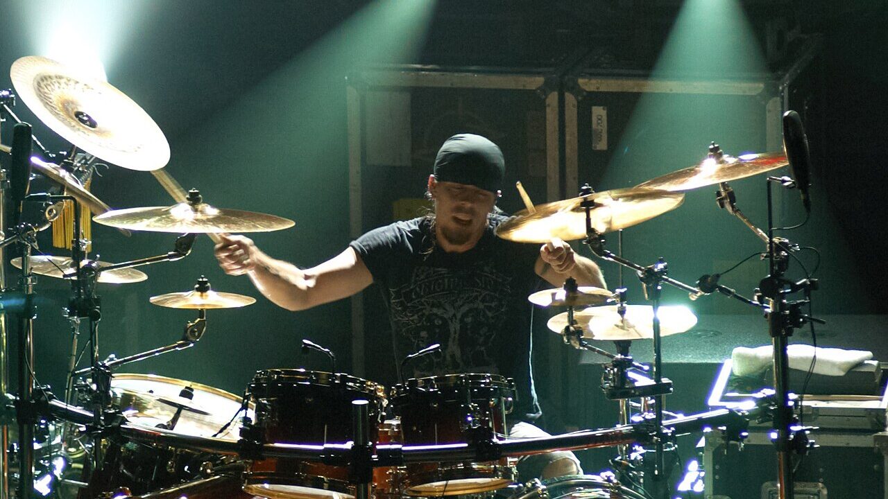 A drummer playing a drum kit on stage