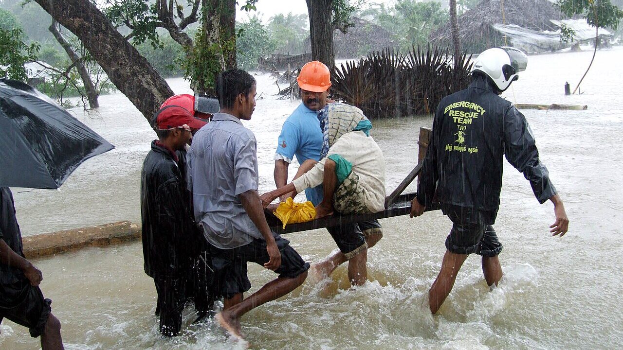A woman being rescued through monsoon floodwater
