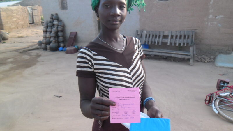 Mother holding her child measles vaccination card outdoors