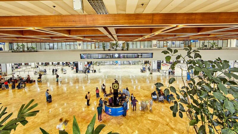 Travellers in an airport departure hall during flight disruptions