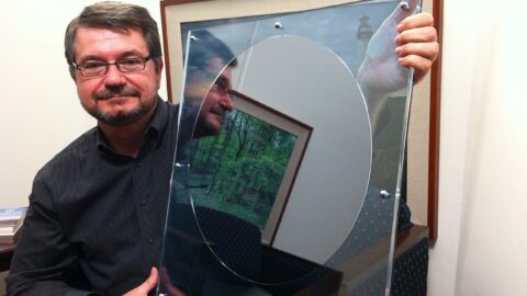An engineer holding a large silicon wafer of the kind used to manufacture computer chips