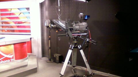 A television studio camera on a tripod in a news studio